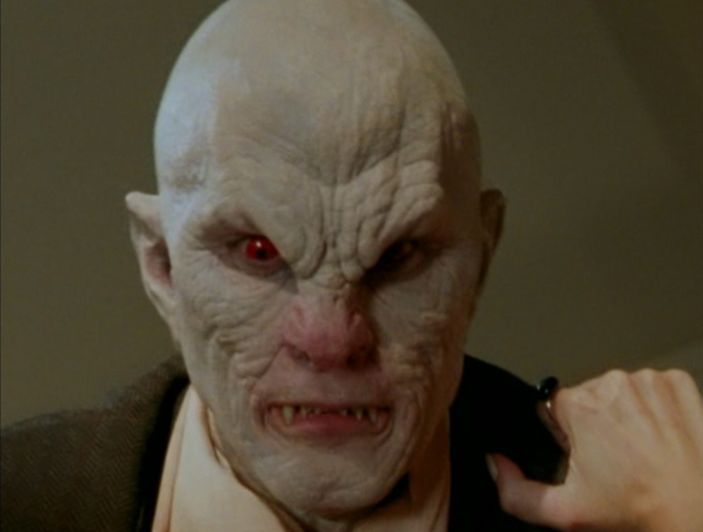 Giles' mask being ripped off to reveal The Master