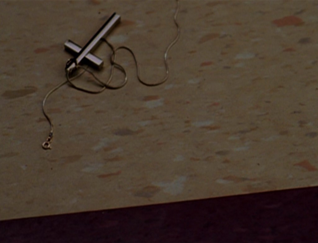 Buffy's crucifix necklace lies discarded on the floor.