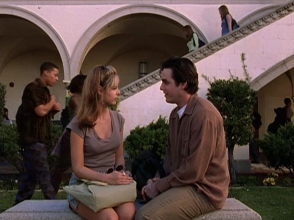 Buffy and Xander sitting across from each other in the High School courtyard.