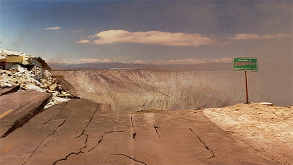 The "Welcome to Sunnydale" sign falls into the crater where Sunnydale once stood.