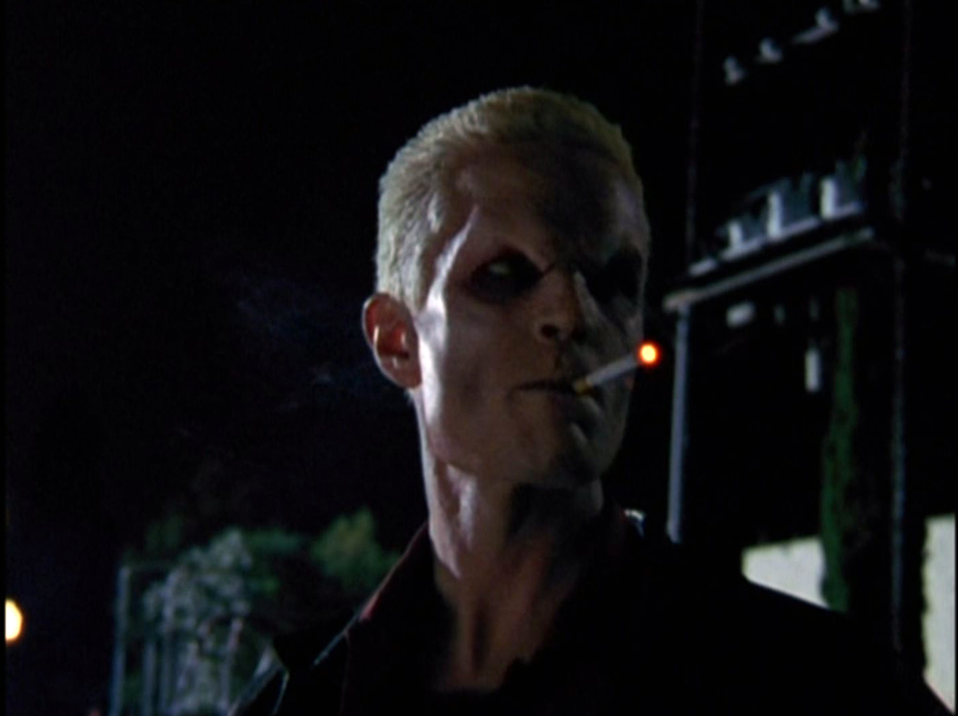 Spike smokes a cigarette outside.