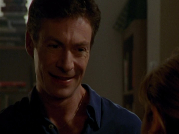 Ethan Rayne talks to Buffy in the library.