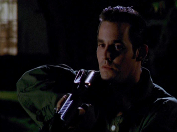 Xander holds up a gun.