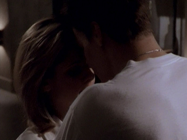 Buffy and Angel almost kiss, bathed in shadow