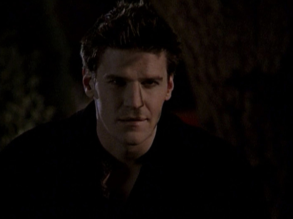 Angelus looks in at Buffy in her house.