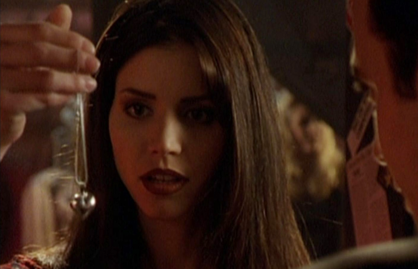 Cordelia holds up Xander's gift of a silver heart necklace