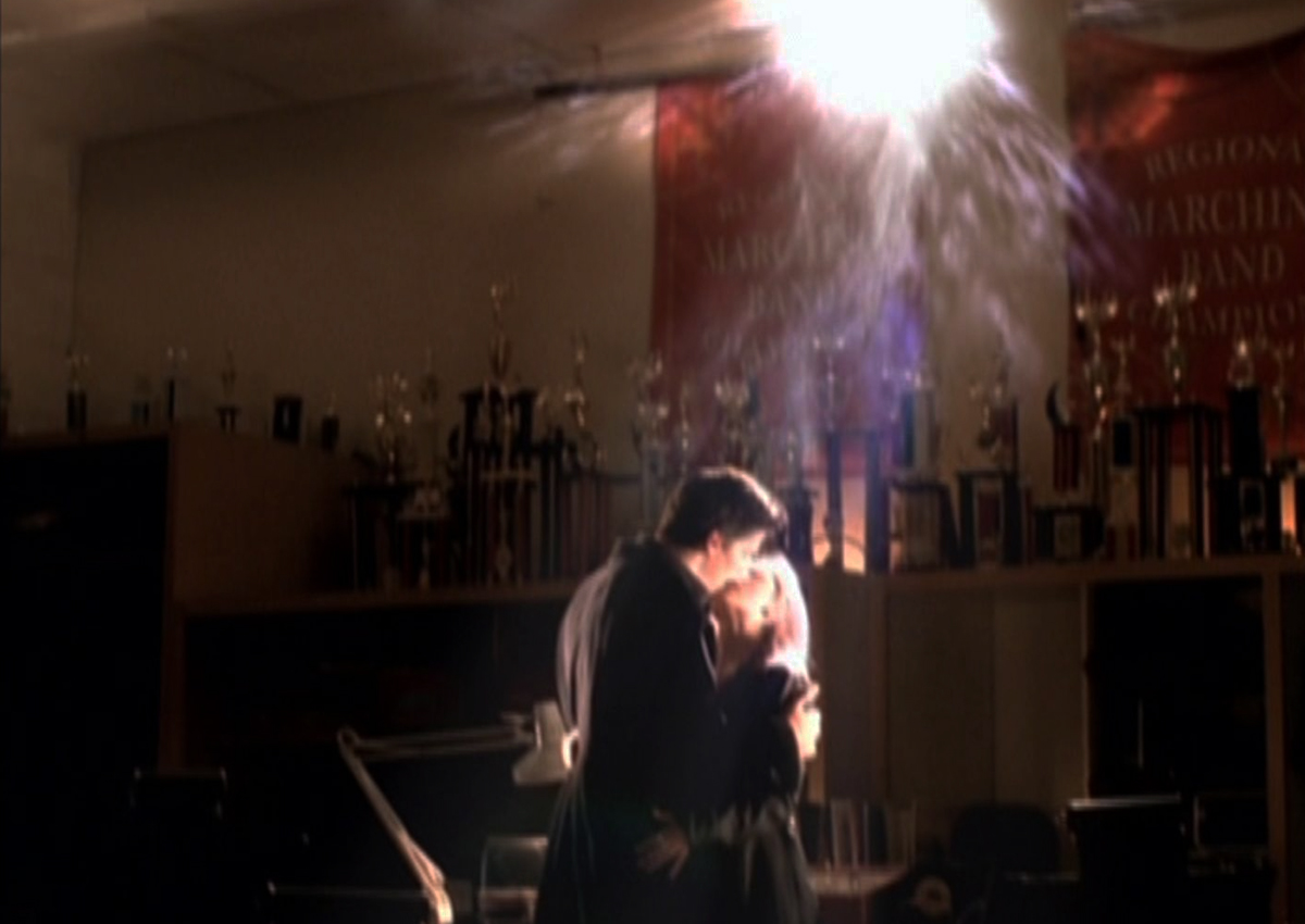 Buffy and Angel kiss underneath a bright light