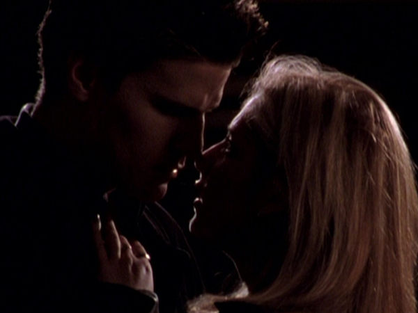 Buffy and Angel holding their faces close together after kissing.