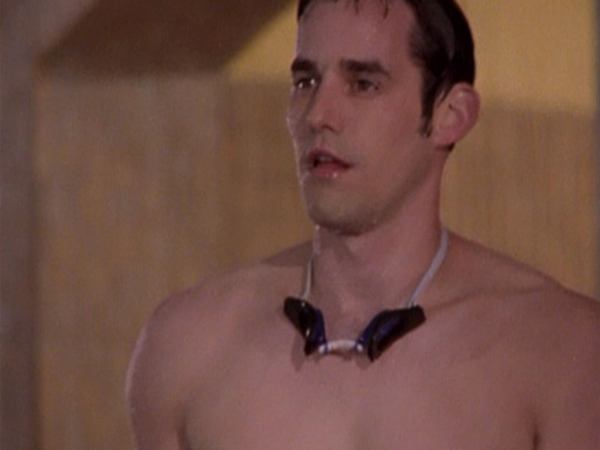 Xander stands, dripping wet and dressed in speedos and a pair of goggles.