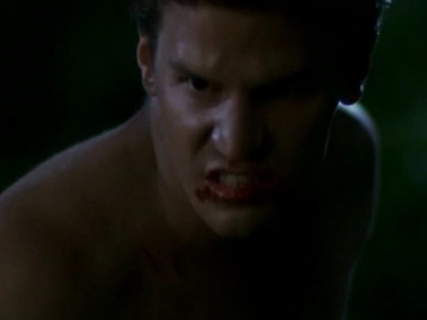 Angel, in his human face and with blood around his lips, snarls.