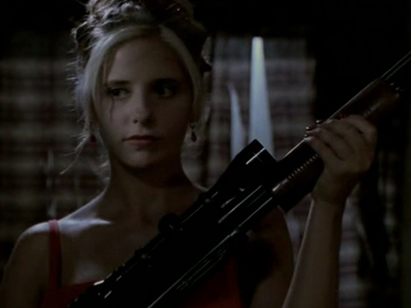 Buffy dressed in her homecoming dress, holding a shotgun.