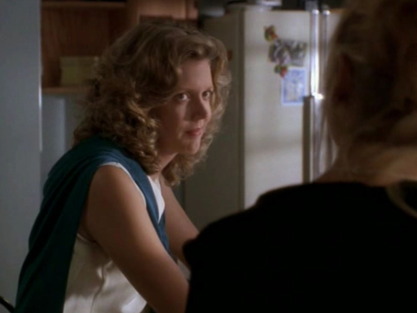 Joyce sits in the kitchen looking skeptically at Buffy.