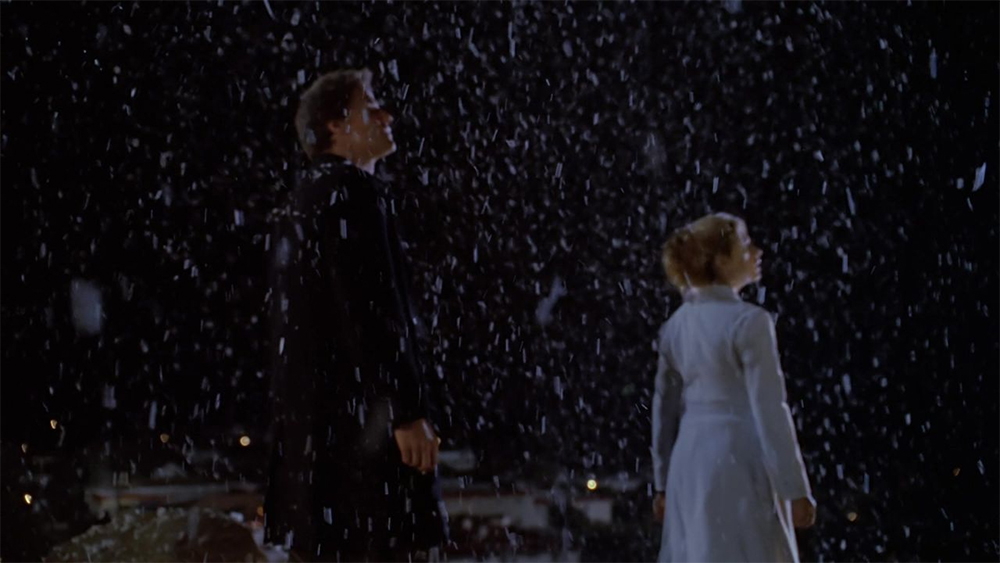 Buffy and Angel look up in awe at snow falling from the sky.