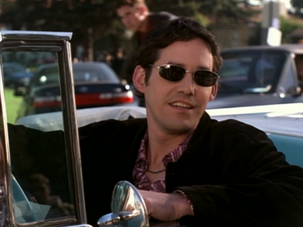 Xander leans out of a car wearing sunglasses.